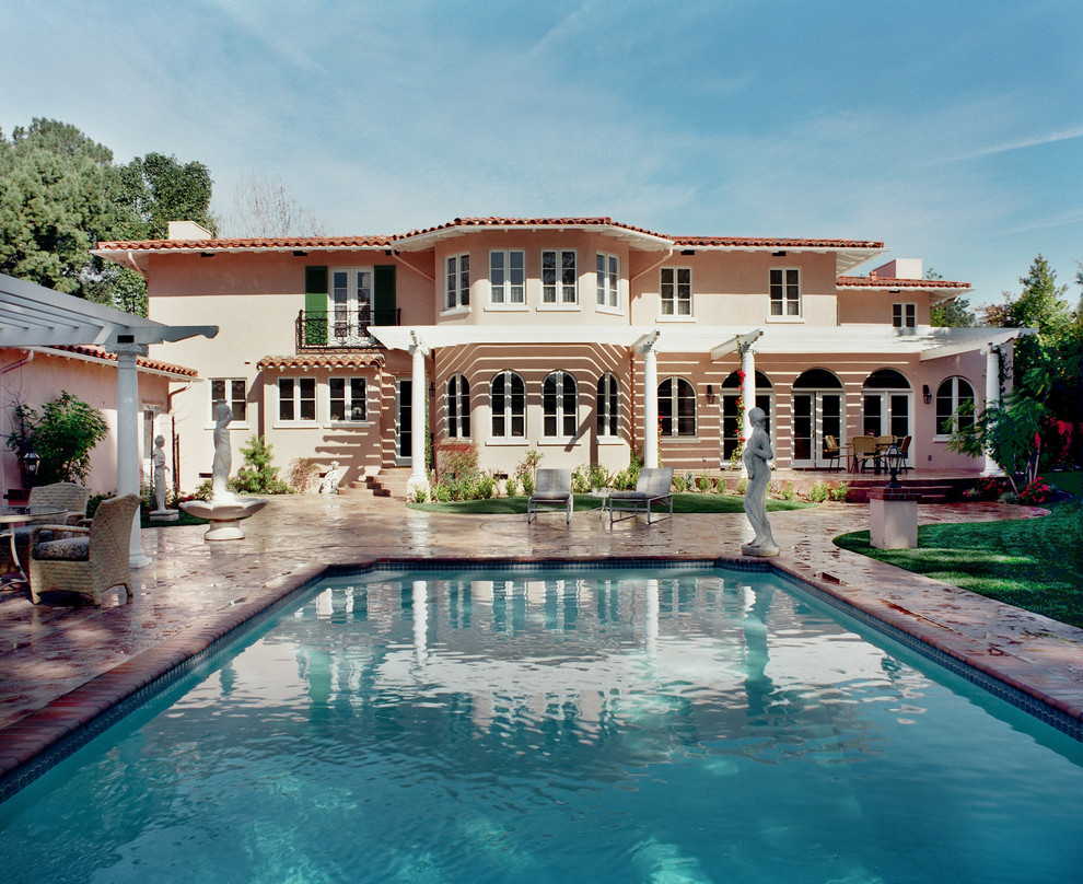 Imagen de piscina alargada mediterránea grande rectangular en patio trasero con adoquines de ladrillo