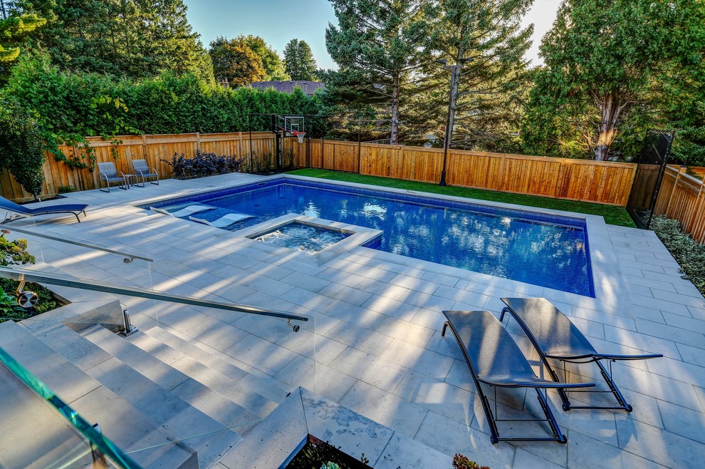 Imagen de piscinas y jacuzzis clásicos renovados de tamaño medio rectangulares en patio trasero con adoquines de piedra natural