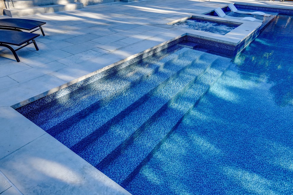 Inspiration pour une piscine arrière traditionnelle de taille moyenne et rectangle avec un bain bouillonnant et des pavés en pierre naturelle.