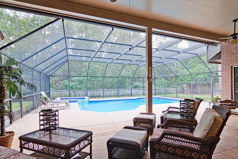 Ispirazione per una piscina tradizionale rettangolare di medie dimensioni e dietro casa con una vasca idromassaggio e piastrelle