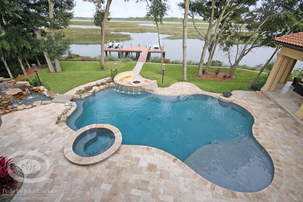 Großer Infinity-Pool hinter dem Haus in individueller Form mit Natursteinplatten in Jacksonville