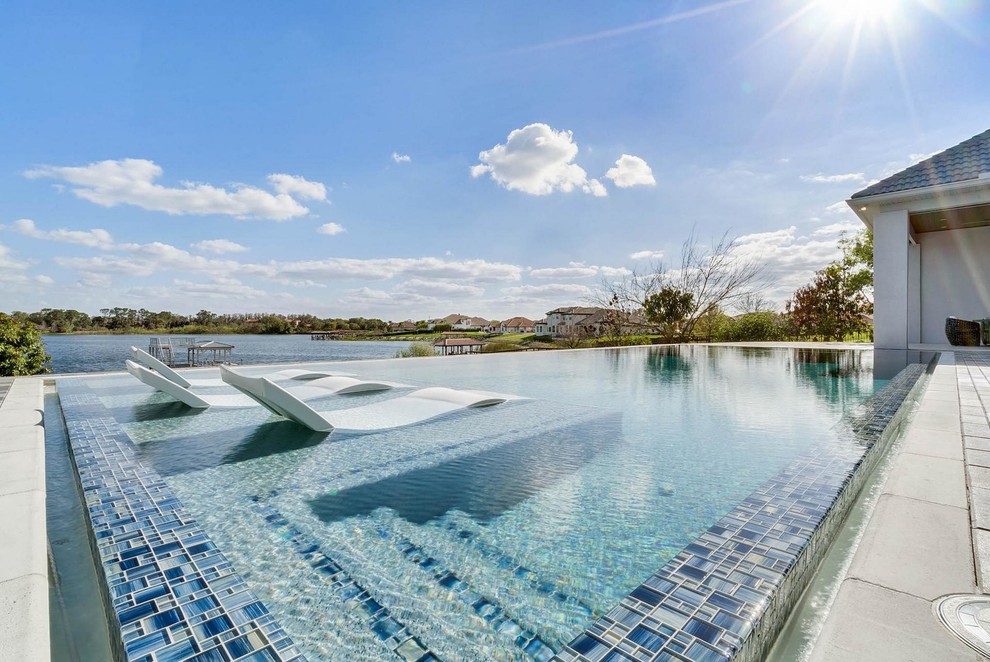 Diseño de piscinas y jacuzzis alargados contemporáneos grandes rectangulares en patio trasero con suelo de baldosas