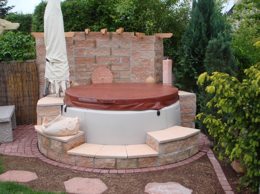 Idee per una piccola piscina fuori terra stile marino rotonda nel cortile laterale con una vasca idromassaggio e pavimentazioni in pietra naturale
