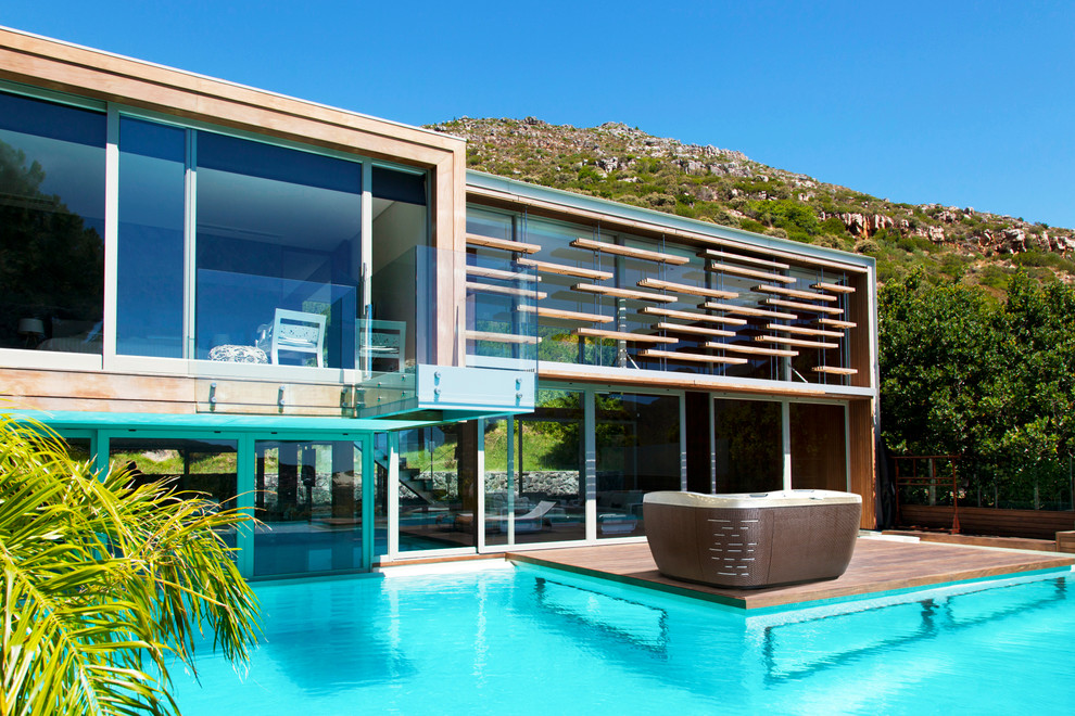 Modelo de piscinas y jacuzzis elevados contemporáneos de tamaño medio rectangulares en patio trasero con entablado