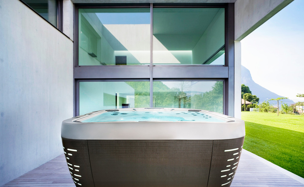 Exemple d'une piscine hors-sol et arrière tendance de taille moyenne et rectangle avec un bain bouillonnant et une terrasse en bois.