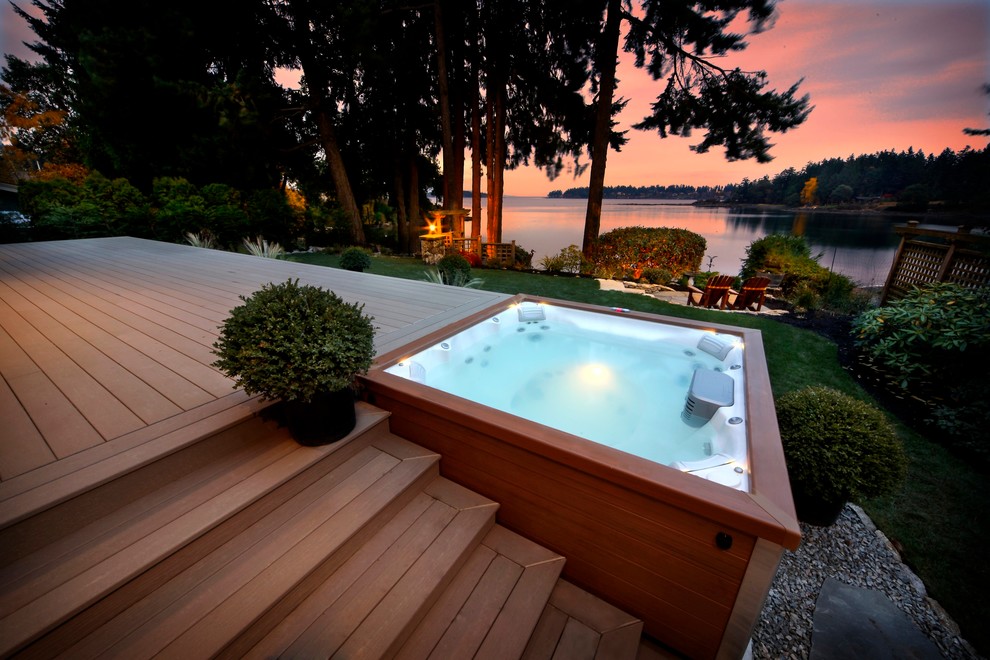 Réalisation d'une piscine hors-sol et arrière craftsman de taille moyenne et rectangle avec un bain bouillonnant et une terrasse en bois.