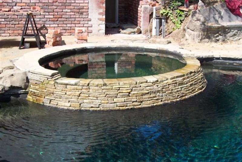 Example of a mid-sized arts and crafts backyard brick and round hot tub design in Los Angeles