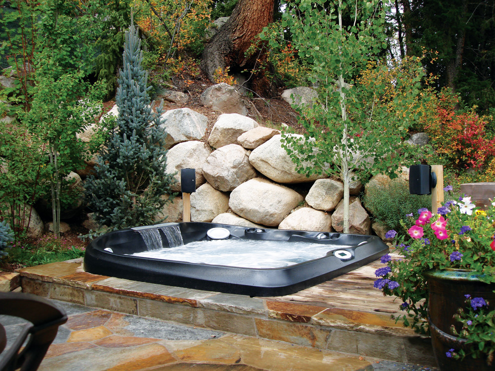 Diseño de piscinas y jacuzzis elevados tropicales pequeños rectangulares en patio trasero con adoquines de piedra natural
