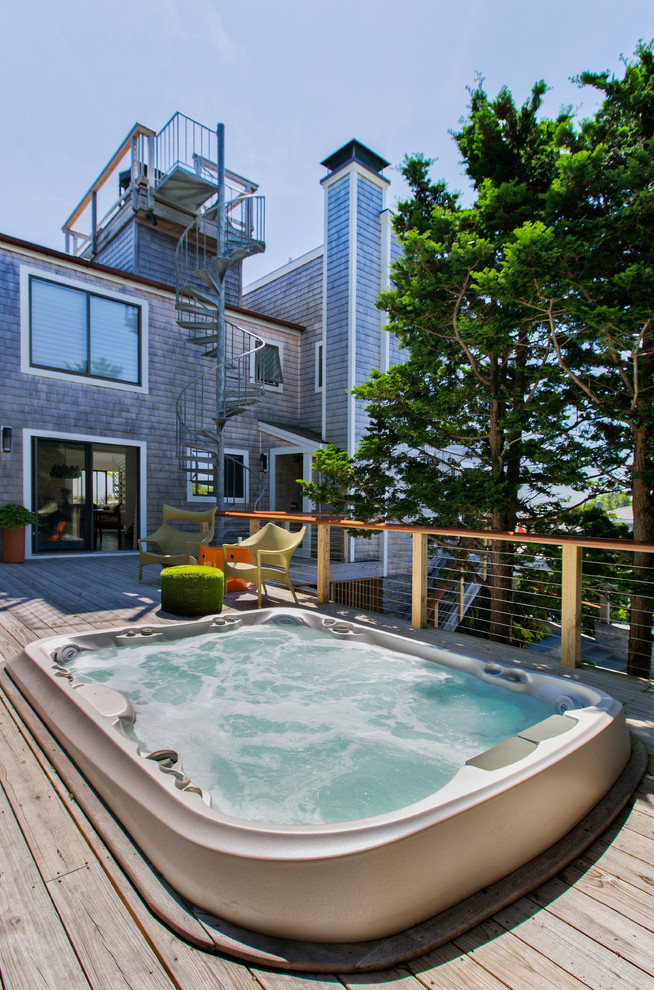 Cette image montre une petite piscine hors-sol et arrière urbaine rectangle avec un bain bouillonnant et une terrasse en bois.