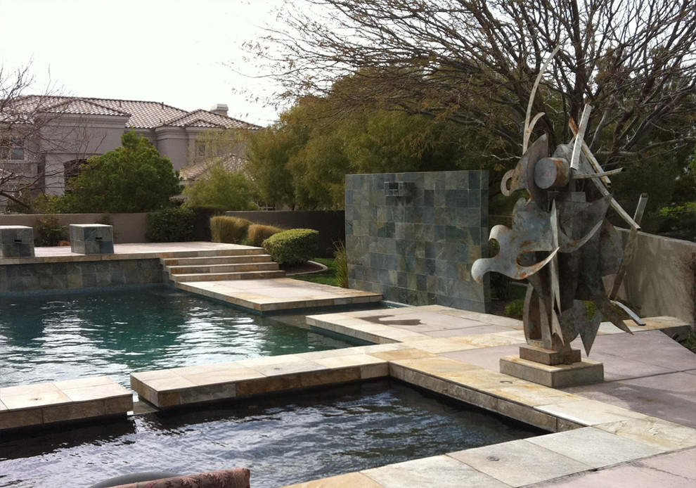 Immagine di una grande piscina monocorsia minimal rettangolare dietro casa con una vasca idromassaggio e piastrelle