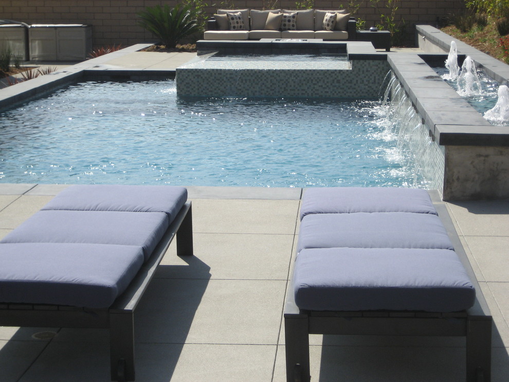 Foto de piscinas y jacuzzis elevados de estilo zen de tamaño medio a medida en patio trasero con losas de hormigón