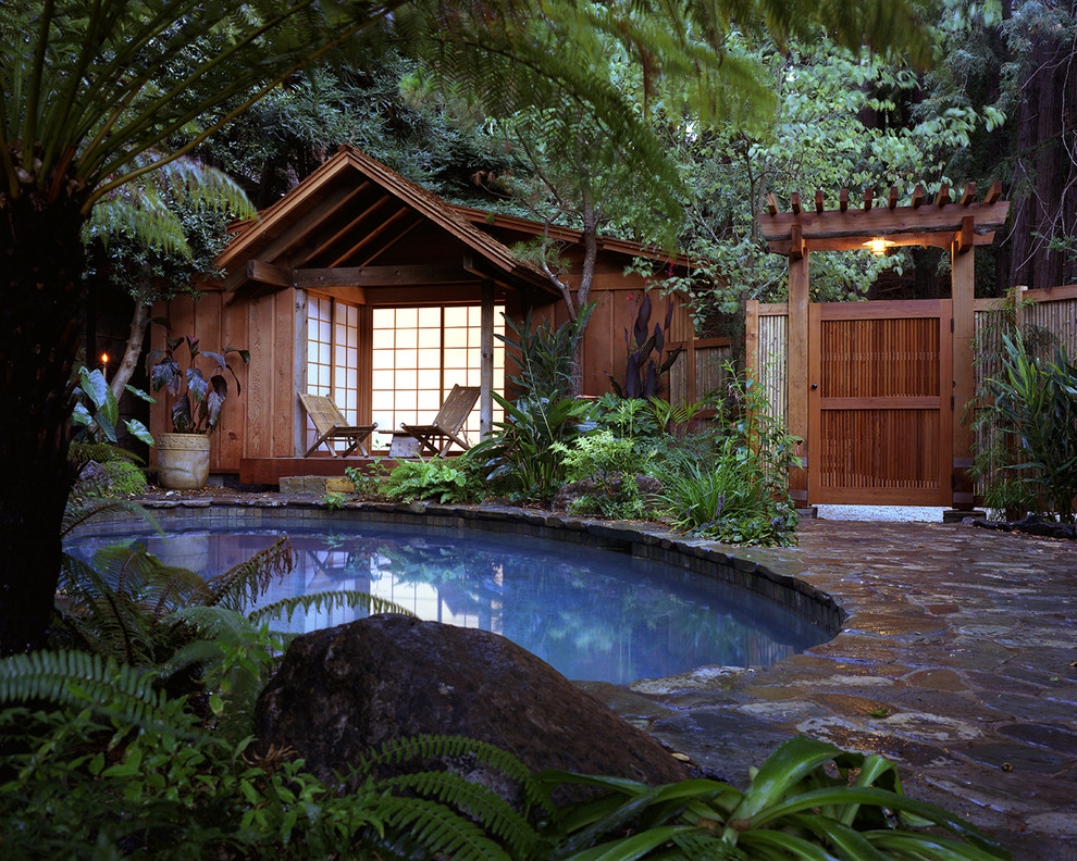 На фото: маленький круглый, естественный бассейн в восточном стиле с домиком у бассейна для на участке и в саду с