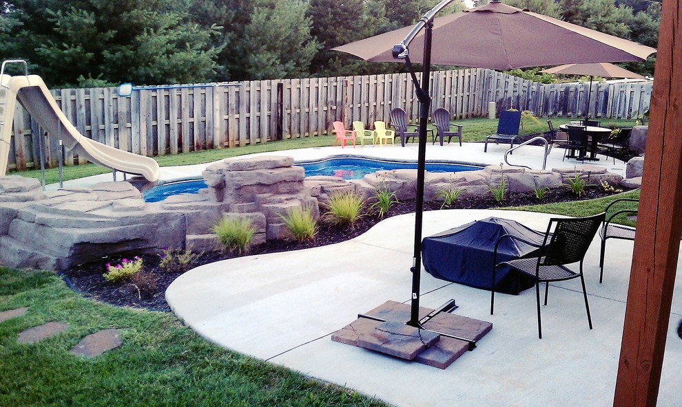 Water slide - large rustic backyard stamped concrete and custom-shaped natural water slide idea in Other