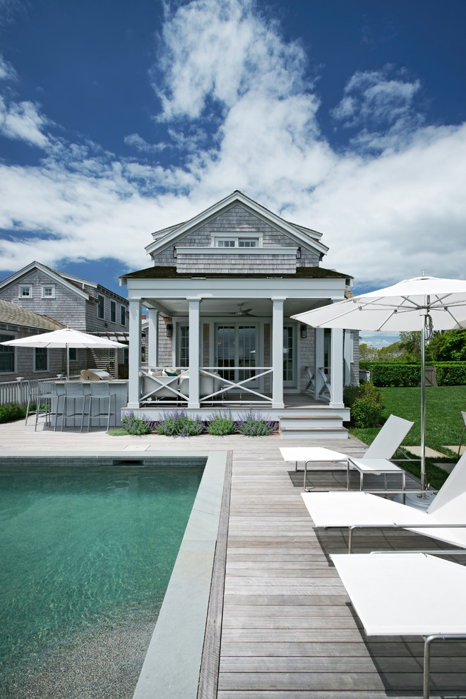 Immagine di una piscina stile marino rettangolare dietro casa con pedane