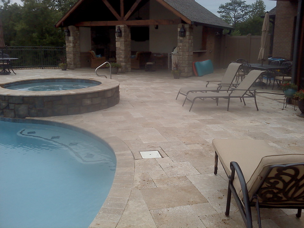 Réalisation d'un grand Abris de piscine et pool houses arrière craftsman sur mesure avec des pavés en pierre naturelle.