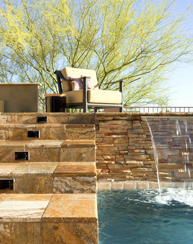 Bild på en funkis rektangulär baddamm på baksidan av huset, med en fontän och naturstensplattor