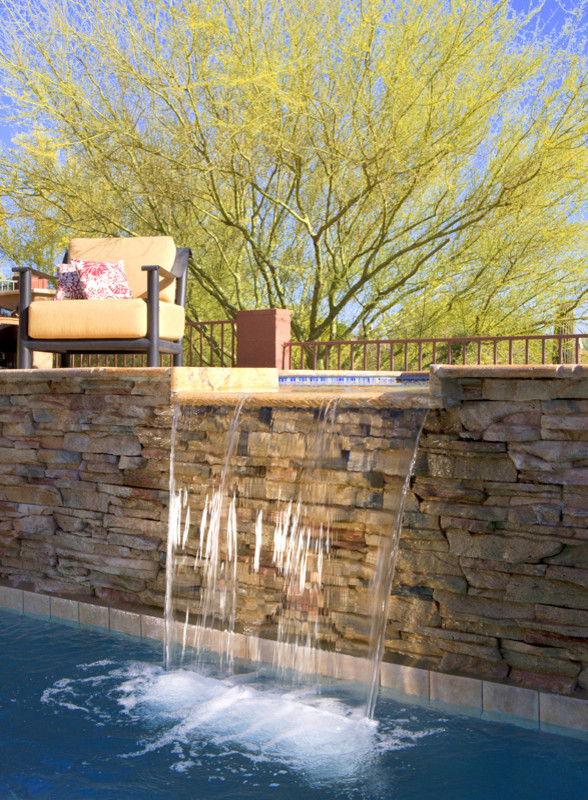 Esempio di una piscina naturale minimal rettangolare dietro casa con fontane e pavimentazioni in pietra naturale