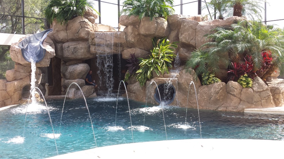 Imagen de piscina con tobogán alargada contemporánea grande en patio trasero