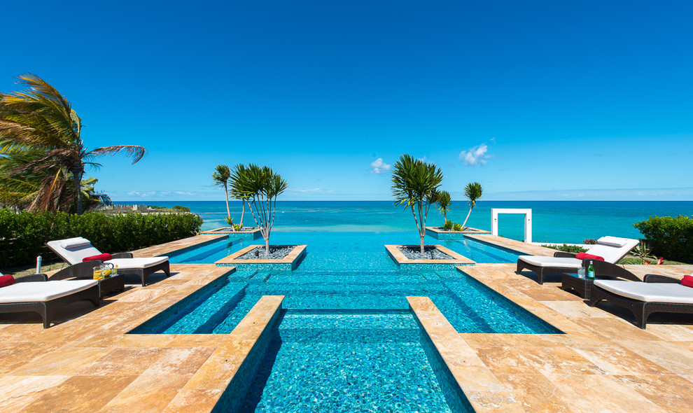 Esempio di una piscina a sfioro infinito tropicale personalizzata