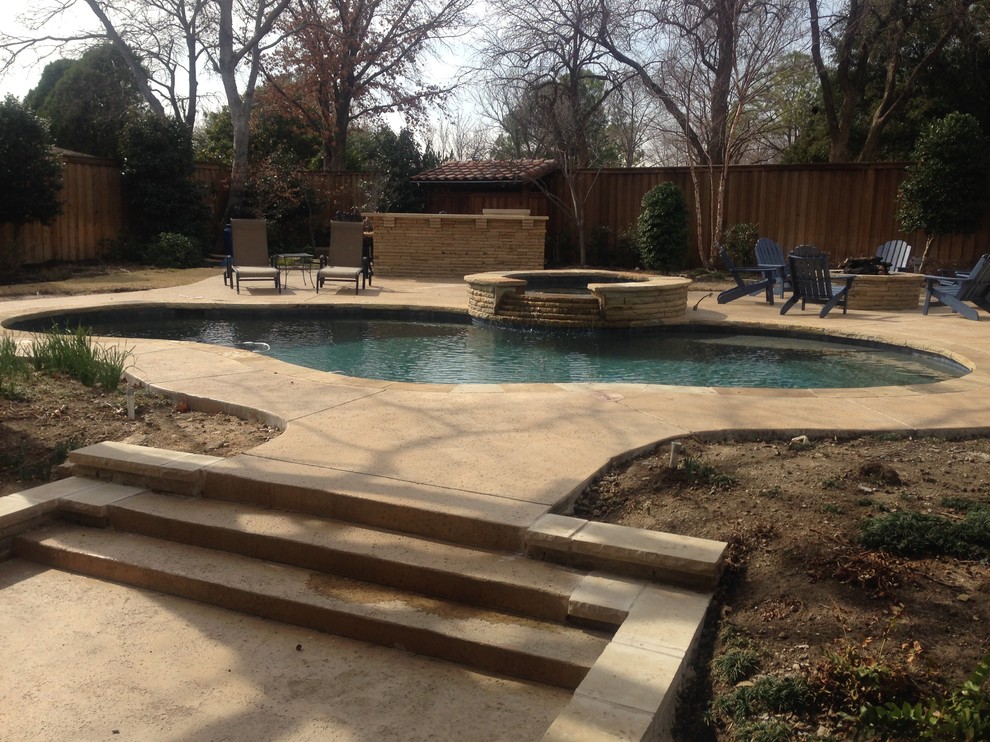 Ejemplo de piscinas y jacuzzis naturales rústicos grandes a medida en patio trasero con suelo de hormigón estampado