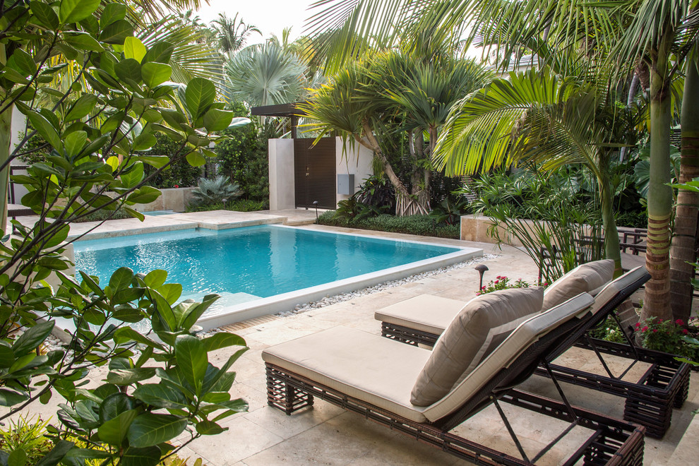 Foto de piscina tropical rectangular con suelo de baldosas