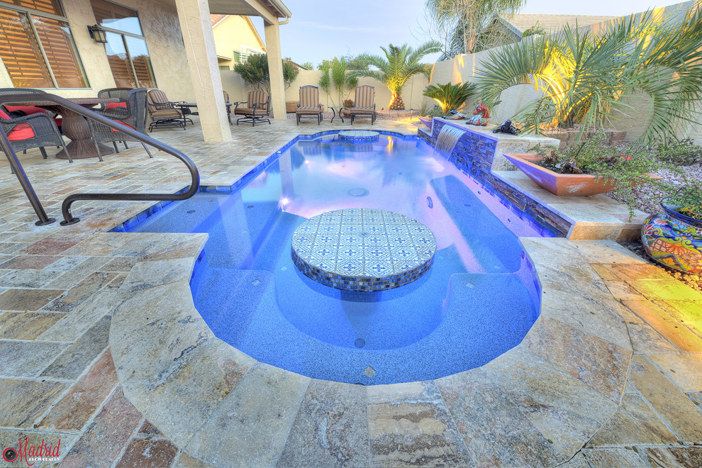 Foto de piscina con fuente de estilo americano pequeña a medida en patio trasero con adoquines de piedra natural