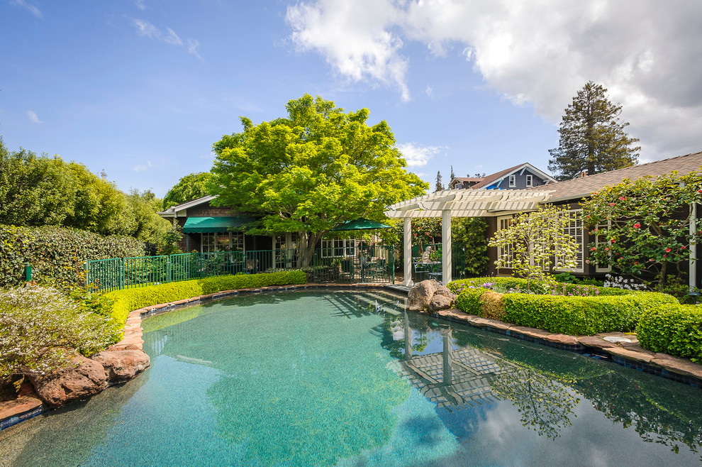 Ispirazione per una piscina naturale american style personalizzata di medie dimensioni e dietro casa con pavimentazioni in pietra naturale