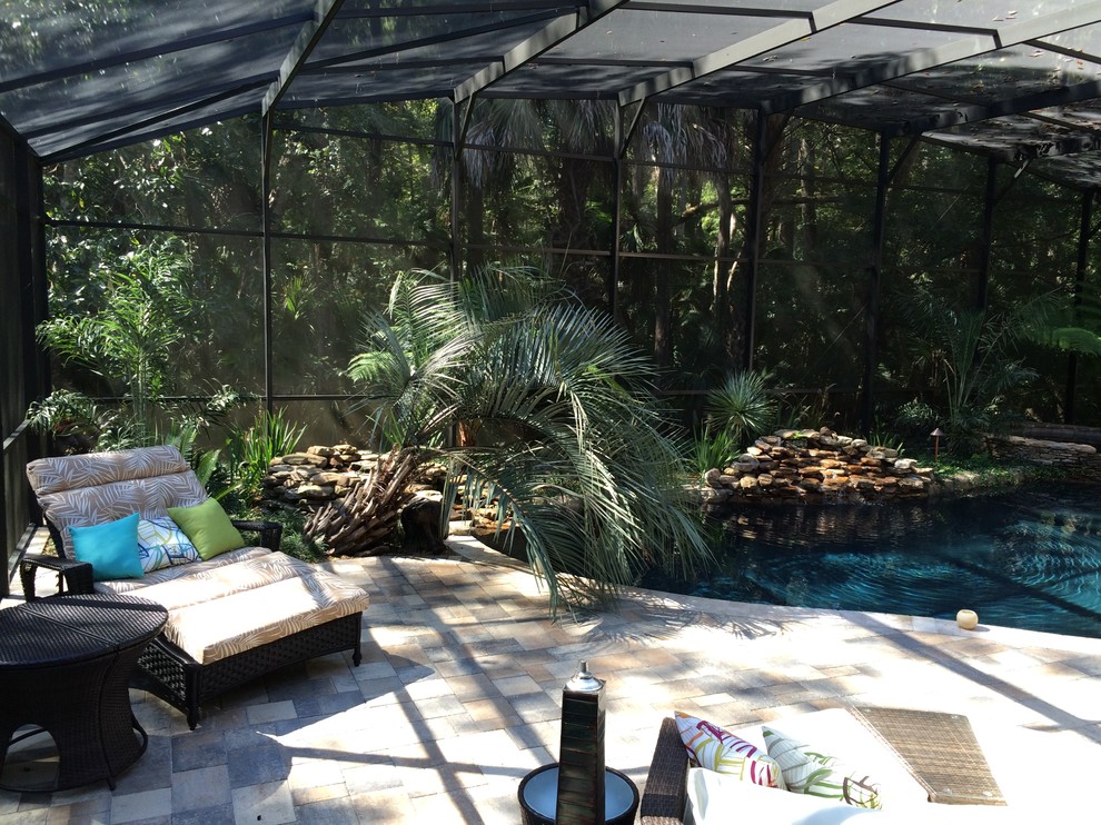 Diseño de piscina con fuente exótica a medida en patio trasero con adoquines de ladrillo
