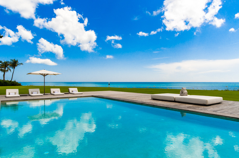 Cette photo montre une très grande piscine naturelle et arrière bord de mer rectangle avec une terrasse en bois.