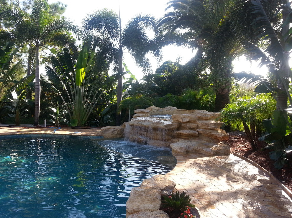 マイアミにあるラグジュアリーな小さなトロピカルスタイルのおしゃれなプール (噴水、天然石敷き) の写真