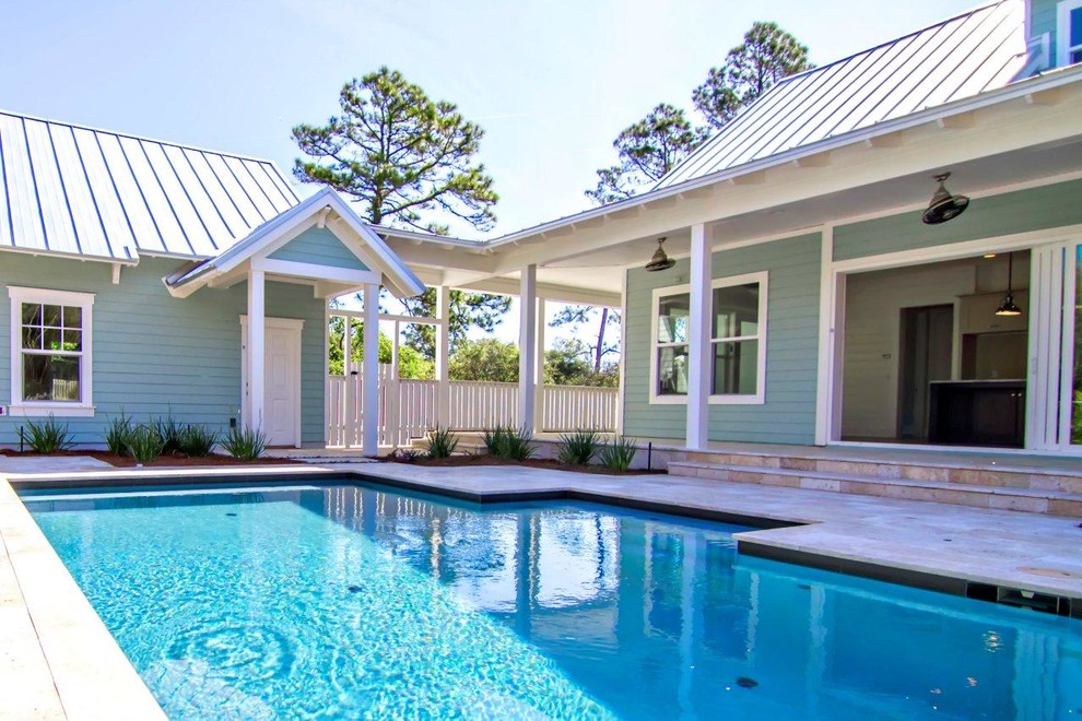 Foto di una piscina stile marinaro rettangolare di medie dimensioni e dietro casa con pavimentazioni in cemento