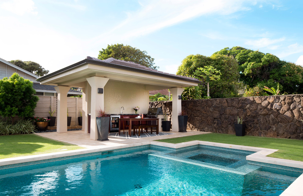 Diseño de piscina alargada contemporánea de tamaño medio rectangular en patio trasero con adoquines de piedra natural