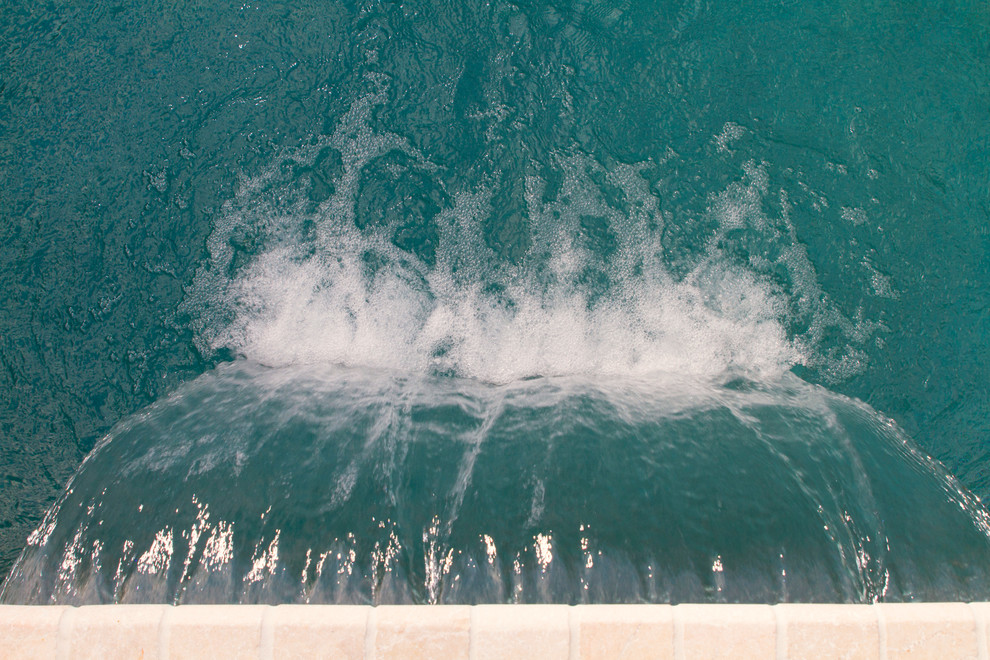 Foto di una piscina moderna personalizzata dietro casa e di medie dimensioni con una dépendance a bordo piscina e pavimentazioni in pietra naturale