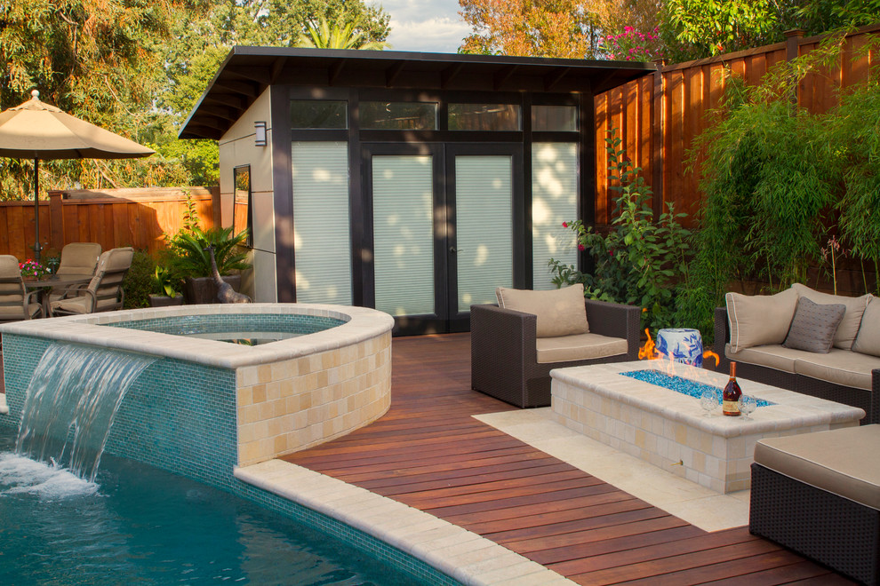Photo of a medium sized modern back custom shaped swimming pool in San Francisco with a pool house and natural stone paving.
