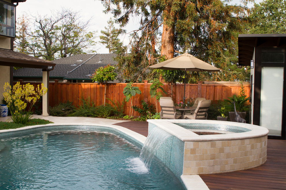 Ejemplo de casa de la piscina y piscina moderna de tamaño medio a medida en patio trasero con adoquines de piedra natural