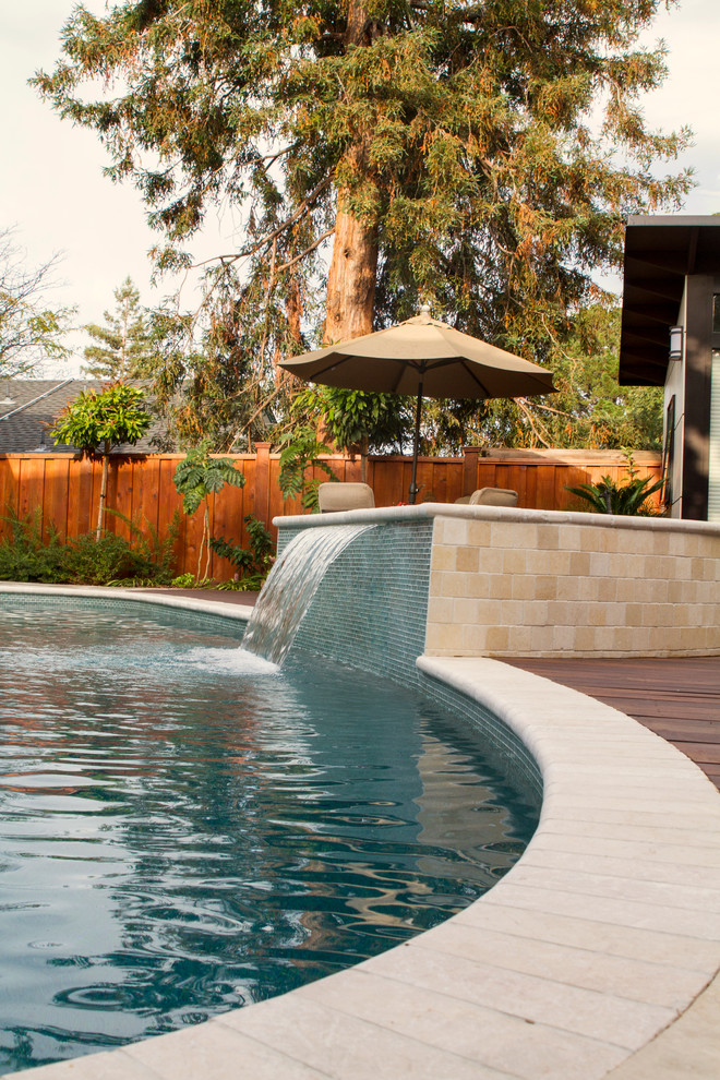 Inspiration för mellanstora moderna anpassad pooler på baksidan av huset, med poolhus och naturstensplattor