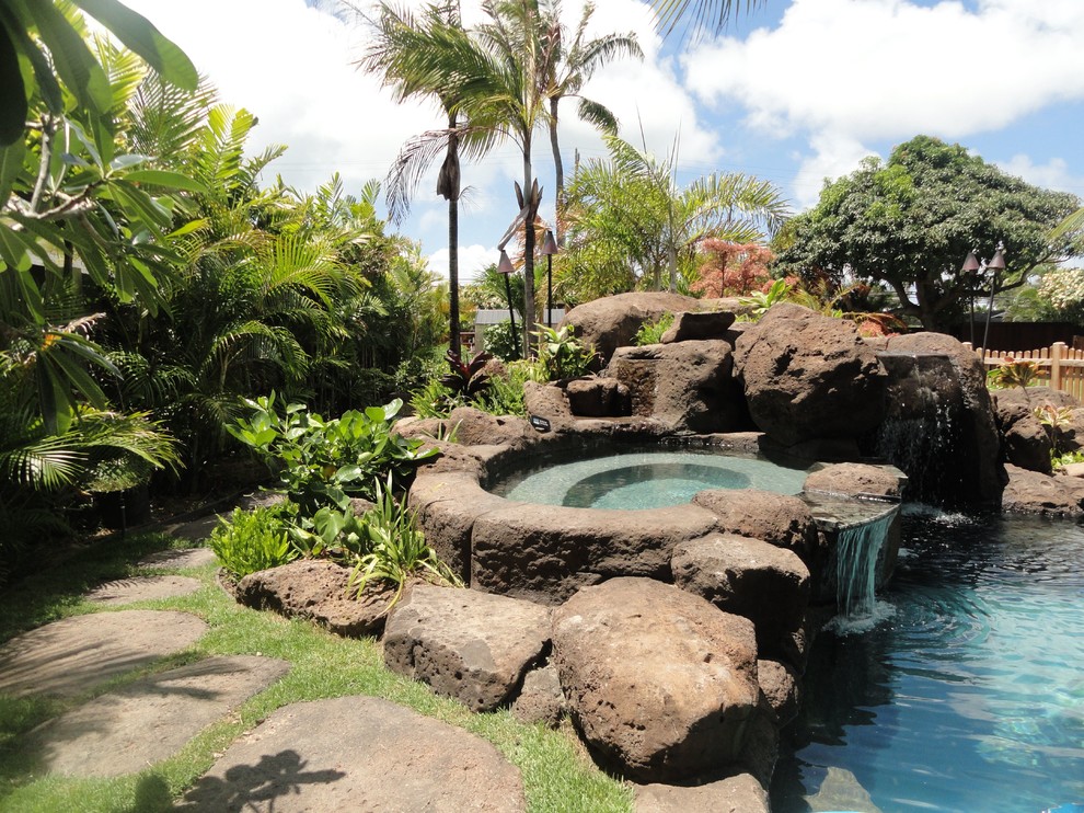 Inspiration for a mid-sized tropical backyard stone and custom-shaped hot tub remodel in Hawaii