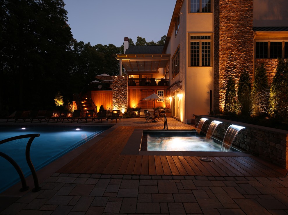 Cette image montre une grande piscine arrière design rectangle avec des pavés en béton.