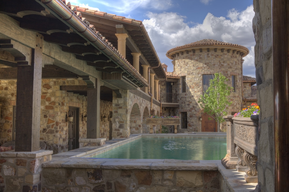 Aménagement d'une grande piscine hors-sol et arrière méditerranéenne rectangle avec des pavés en pierre naturelle.