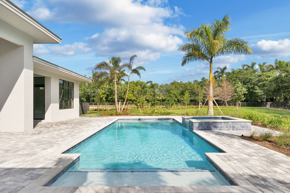 Mittelgroßer Klassischer Pool hinter dem Haus in rechteckiger Form mit Pflastersteinen in Miami