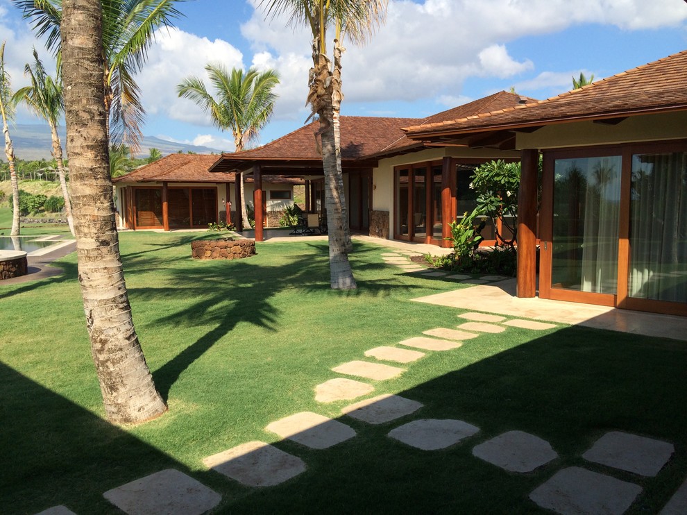 Diseño de piscinas y jacuzzis infinitos tropicales grandes rectangulares en patio trasero con adoquines de hormigón