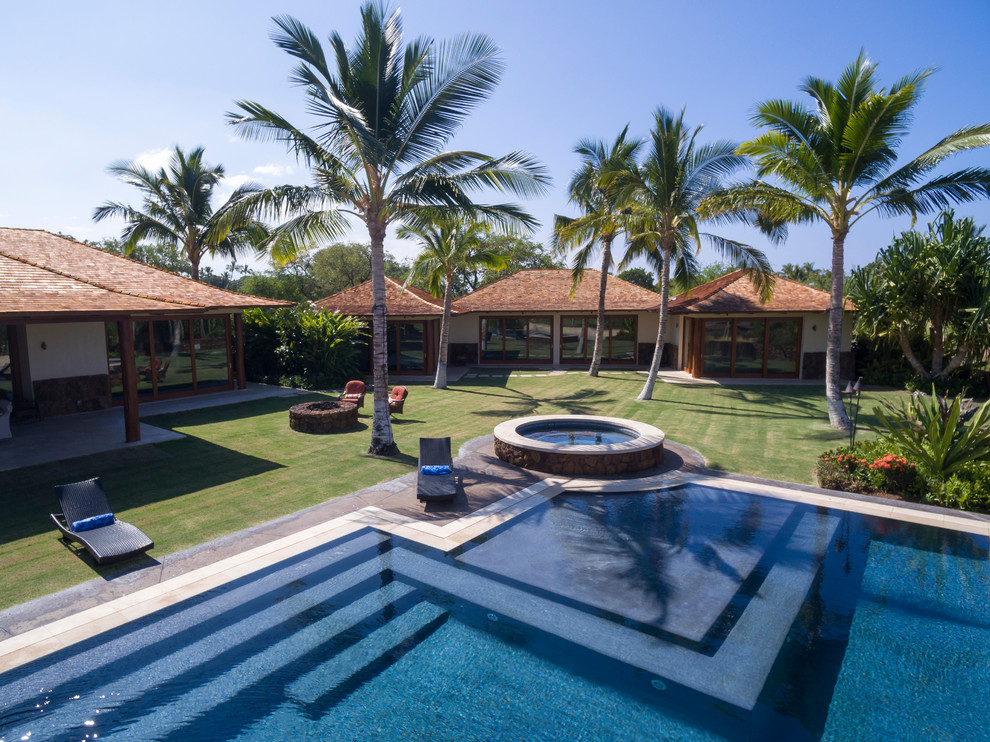Diseño de piscinas y jacuzzis infinitos exóticos grandes rectangulares en patio trasero con adoquines de hormigón