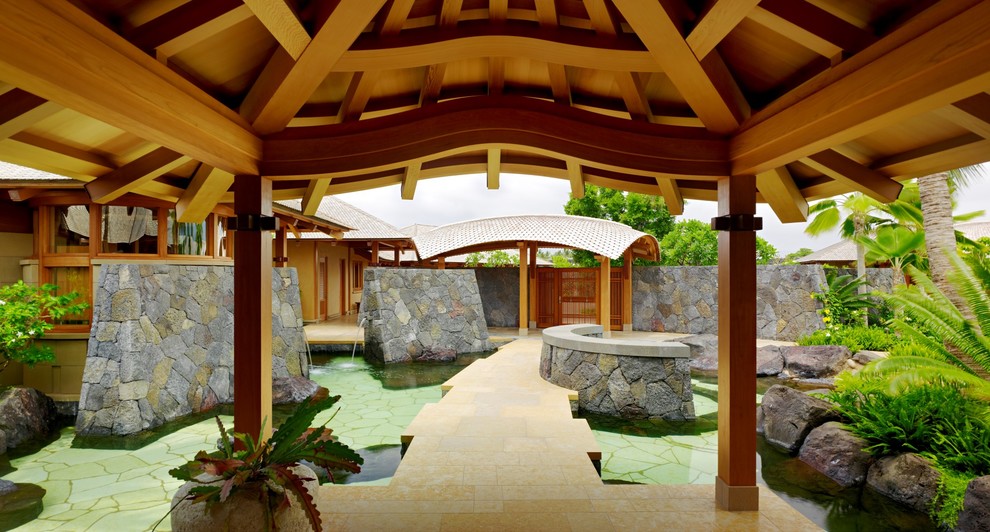 Ispirazione per una piscina naturale tropicale personalizzata con pavimentazioni in pietra naturale