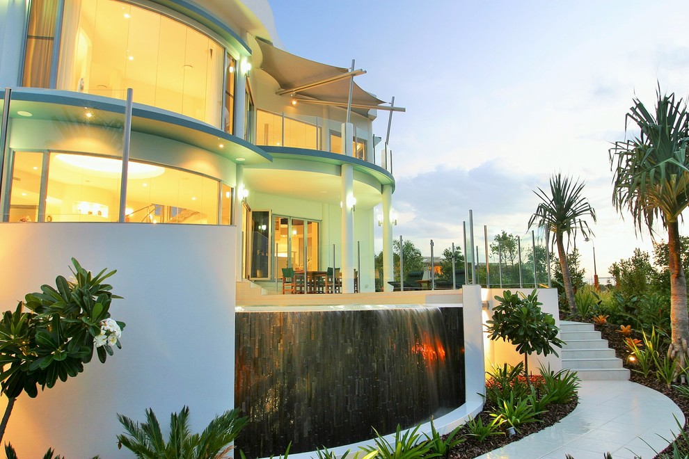 Idéer för stora tropiska anpassad infinitypooler på baksidan av huset, med kakelplattor och spabad