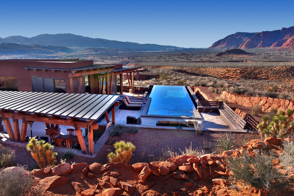 Foto de piscina alargada retro de tamaño medio rectangular en patio trasero con losas de hormigón