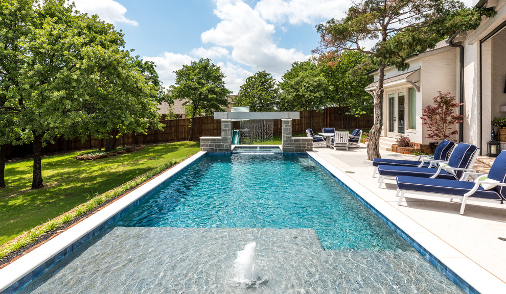 Ejemplo de piscina con fuente alargada contemporánea rectangular en patio trasero con losas de hormigón