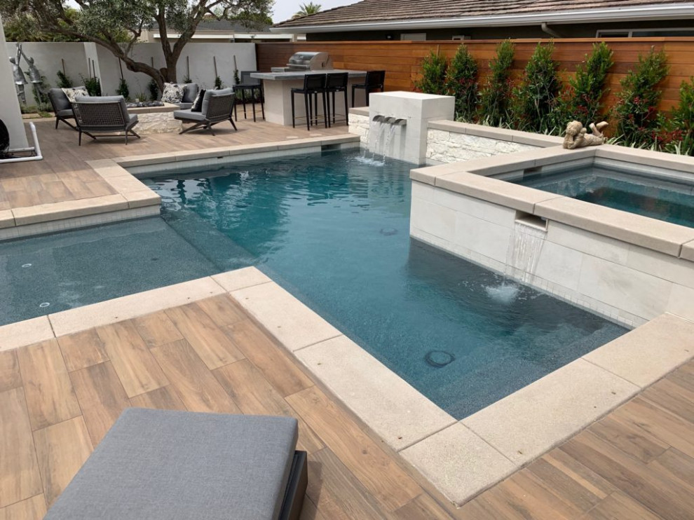 Immagine di una piscina design personalizzata di medie dimensioni e dietro casa con fontane e pavimentazioni in cemento