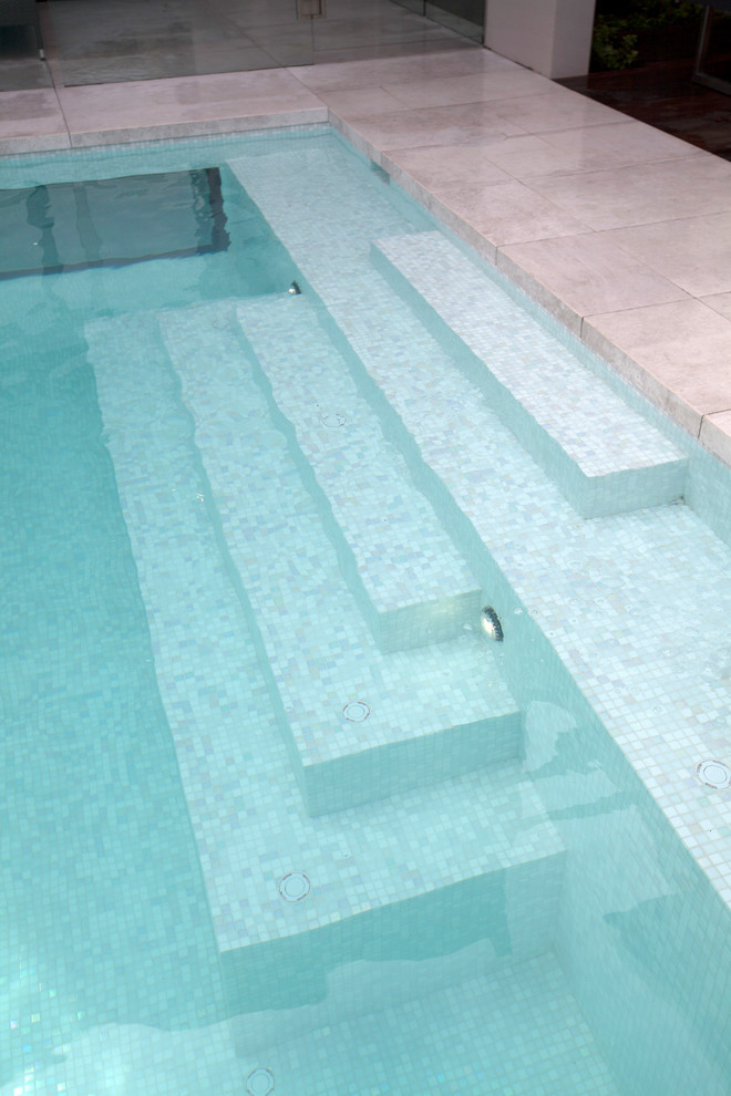 Imagen de piscina con fuente moderna grande rectangular en patio trasero