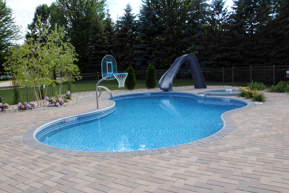 Idées déco pour une piscine latérale classique de taille moyenne et sur mesure avec des pavés en béton et un toboggan.