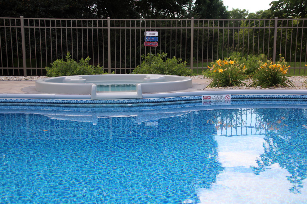 Ejemplo de piscinas y jacuzzis tradicionales de tamaño medio a medida en patio lateral con adoquines de hormigón